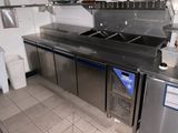 une cuisine équipée de plans de travail et d'un évier en inox