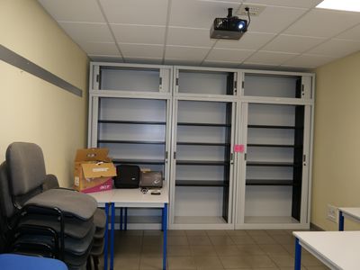 a room with a desk, chairs, and a projector in it