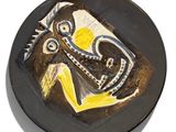 a black plate with a yellow and white painting on it