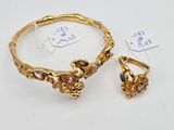 a close up of a gold bracelet and earring with a price tag