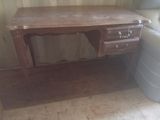 un bureau en bois avec des tiroirs et une chaise dans un coin
