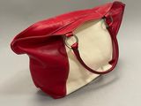 the red and white bag is sitting on a white surface