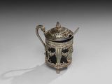 une théière ancienne en argent avec son couvercle, posée sur une surface blanche