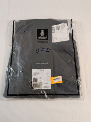 un sac de vêtements emballé dans du plastique posé sur une surface blanche