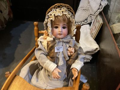a doll that is sitting on a chair in a room
