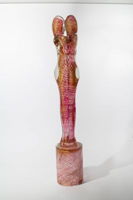 une sculpture en verre représentant une femme tenant un oiseau sur un socle