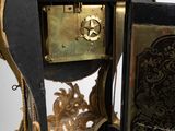 a black and gold clock sitting on a white surface
