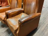 leather recliners are lined up in a warehouse with other furniture