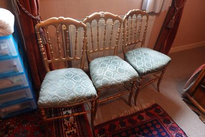 trois chaises placées les unes à côté des autres dans une pièce