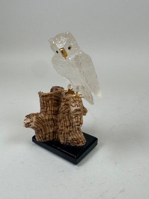 figurine d'une chouette blanche perchée sur une souche d'arbre