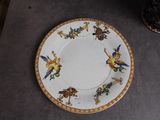 a plate with a bird design on it sitting on a table