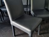 several black leather chairs are lined up in a row in front of a brick wall