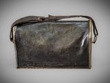 an old black leather purse with a brown strap