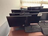 four computer monitors sitting on a desk next to a keyboard and mouse