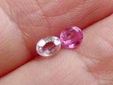 quelqu'un tient dans sa main une paire de saphirs roses