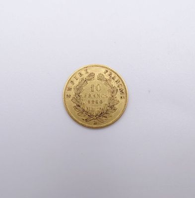 gros plan d'une pièce d'or sur une surface blanche
