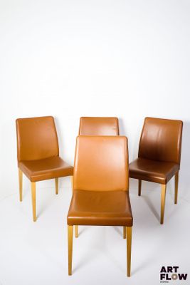 four brown leather chairs are arranged in a circle on a white background