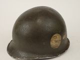 an old helmet with a wooden sticker on it sitting on a white surface