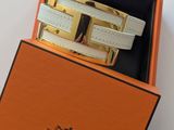 une boîte orange contenant une paire de bracelets en cuir blanc