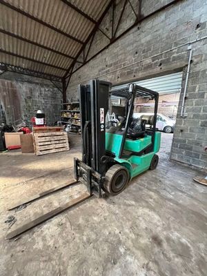 un chariot élévateur dans un entrepôt, avec des palettes au premier plan