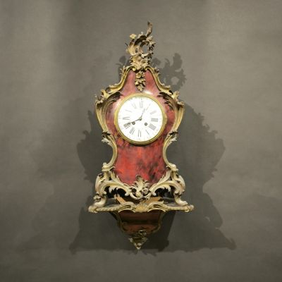une horloge rouge et dorée accrochée au mur
