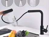 un robinet noir d'où coule de l'eau dans un évier
