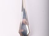 a silver spoon with a mirror on it on a white surface