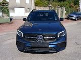 the mercedes gle is parked on the side of the road in front of a house