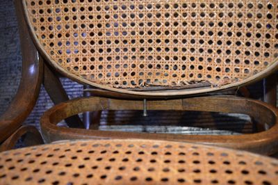 un gros plan d'une chaise en bois percée de trous