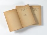 deux livres ouverts posés sur une surface blanche, sur lesquels figurent des inscriptions