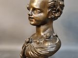 a close up of a bronze statue of a child on a pedestal