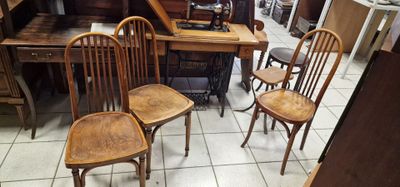 quatre chaises en bois et une table dans une pièce