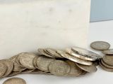 un bloc de marbre blanc sur lequel est posée une pile de pièces de monnaie
