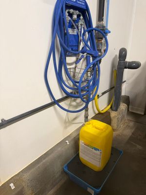 un récipient jaune muni d'un tuyau bleu et un récipient jaune sur lequel est fixé un tuyau bleu