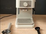 a coffee maker sitting on a table next to a measuring spoon