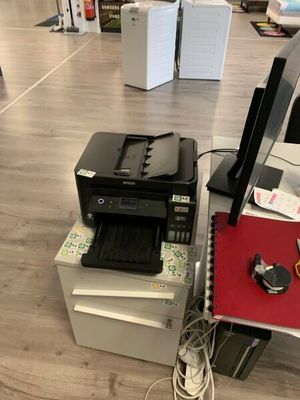 une imprimante posée sur un bureau à côté d'une imprimante