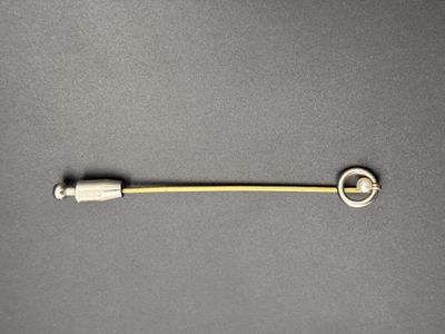 un gros plan d'un petit objet métallique posé sur une surface grise