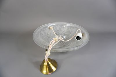 un bol en verre sur une table, surmonté d'une clochette dorée
