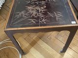 une personne debout à côté d'une table sur laquelle figure un motif en noir et blanc