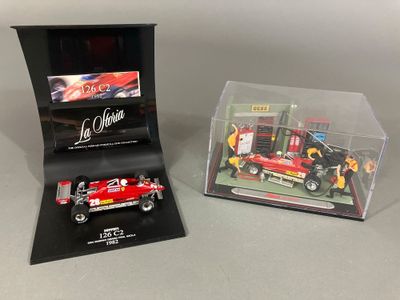 La boîte est ouverte et laisse apparaître une maquette de voiture de course et une maquette de voiture.