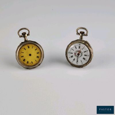 deux petites montres de poche posées côte à côte sur une surface blanche