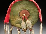 un tambour vert et rouge avec des plumes qui pendent sur le côté