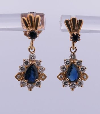 une photo d'une paire de boucles d'oreilles ornées de saphirs et de diamants