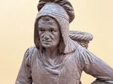 a statue of a woman standing with her hands on her hips