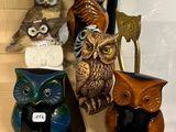 de nombreuses figurines de chouettes toutes différentes posées sur une étagère