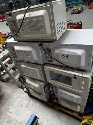 plusieurs fours à micro-ondes empilés les uns sur les autres dans un entrepôt