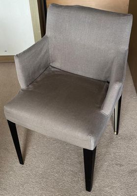 une chaise posée sur le tapis dans la pièce