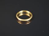 gros plan d'une bague en or sur une surface noire