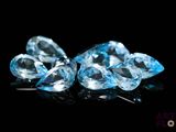 three pieces of blue topazte on a black surface