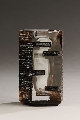 sculpture représentant un objet marron et noir sur une surface blanche